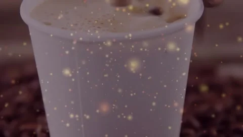 Camera pulling back showing coffee cup, gold glow drifting, foam settling, beans Stock Footage 330577876