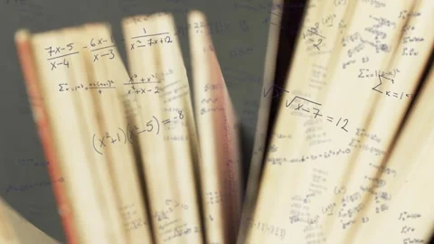 Camera pulling back, two open books fanning pages, revealing math notation for Stock Footage 334743908