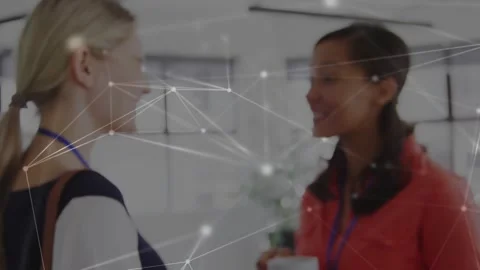 Camera pulling back, two women smiling holding cups at business event network Stock Footage 330936191