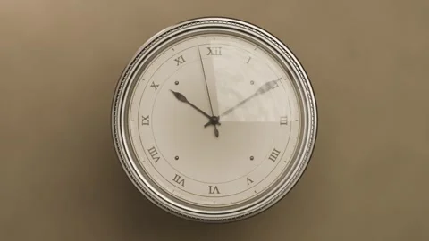 Camera pulling closer showing round Roman clock on beige wall hands rotating Stock Footage 337505116