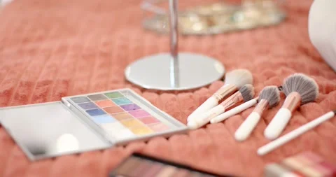 Camera is pulling focus and shifting right, revealing makeup brushes and Stock Footage 346643717