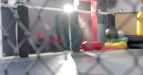 Camera is pulling focus from chain-link fence to reveal mats and hanging bags Stock Footage 334923196