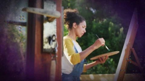 Camera pulling focus from door keys, woman mixing paint and painting canvas, Stock Footage 333893783
