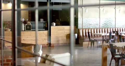Camera is pulling focus to showcase cafe counter with espresso setup, seating Stock Footage 342493257