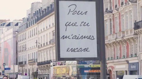Camera Pulls Back from Minimalist Billboard to Reveal Busy Paris Street Scene Stock Footage 333383167