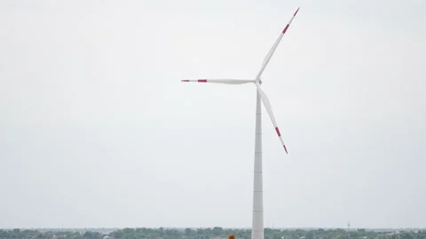 Camera pulls back to show an aerial view of a long row of offshore wind turbines Stock Footage 201121767