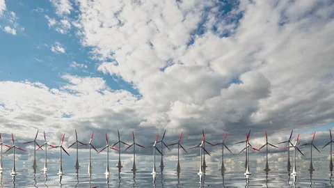 Camera pulls back through rotating blades of a wind turbine in an offshore wind Stock Footage 256639516