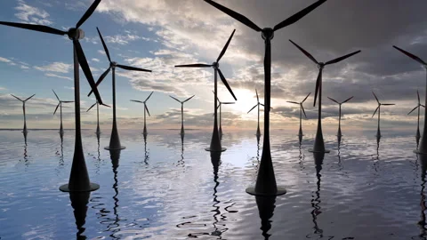 Camera pulls back through rotating blades of a wind turbine in an offshore wind Stock Footage 258162803