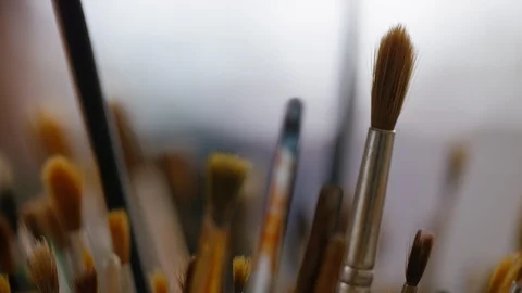 Camera pulls focus between a jar of paint brushes Stock Footage 112026752