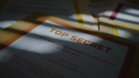 Camera pulls out from close up of Top Secret labeled manila folder in dark room Stock Footage 316317542