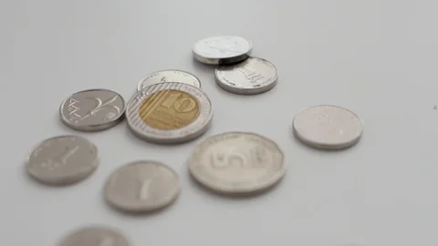 Camera pulls out revealing different Israeli coins set on white background Stock Footage 109482146