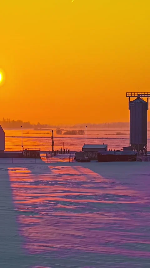 Camera Pulls In Toward Farm Grain Silos at Golden Winter Sunset Stock Footage 342470094
