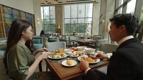 Camera pushes in and out on a couple eating at a luxury hotel restaurant in Stock Footage 335433076