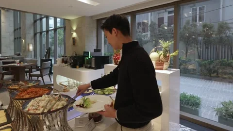 Camera pushes in and out on a man serving food at a luxury resort restaurant Видео 335433041