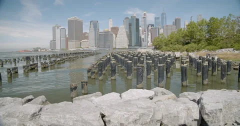 Camera pushes over rocks from Brooklyn towards Manhattan. Stock Footage 131191200