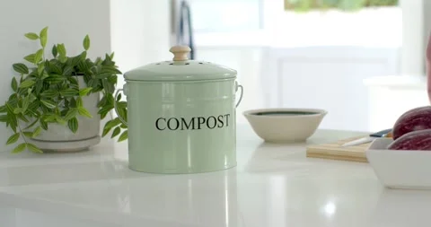 Camera is pushing forward, showing pastel green compost bin on glossy counter Video stock 344964429
