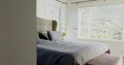 Camera is pushing right from doorway, revealing tufted headboard, grey bed and Stock Footage 341320644