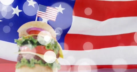 Camera pushing, stacked cheeseburger rising, mini US flag centering, bokeh Stock Footage 329835639