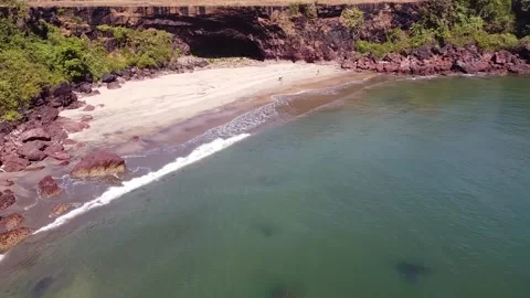 The camera quickly flies over the beach, the waves are nailed to the shore. Video stock 228685153