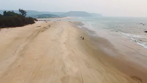 The camera quickly flies over a sandy beautiful beach, a view from a height,. Video stock 228685109