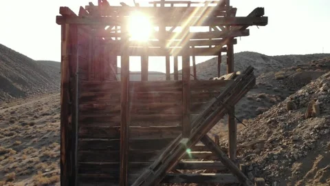 Camera Raises Up Side of Abandoned Gold Mine Bin with Sun Flare - Aerial Stock Footage 188679273