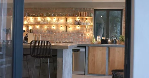 Camera recording static kitchen island and brick backsplash under string lights Vídeo Stock 338325561