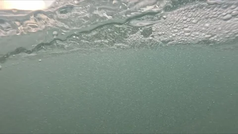 Camera records both underwater and surface view of the sea with air bubbles.. Stock Footage 318488485