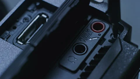 Camera repair person using a small screw driver to drive in a tiny screw Stock Footage 255218599