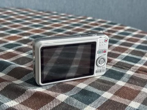 Camera rests on checkered tablecloth in indoor setting Stock Photos