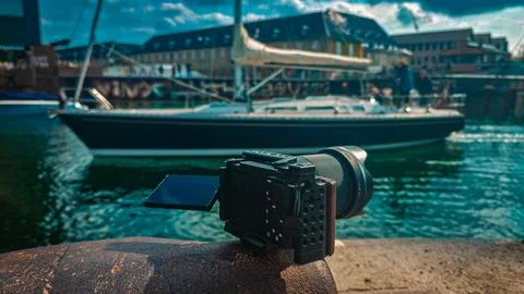 Camera rests on stone, pointed at harbor scene Fotos Stock