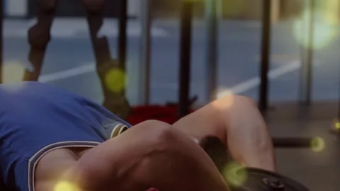 Camera revealing man lying on bench, gripping dumbbell, doing pullover for Stock Footage 330509436