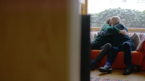 Camera reveals father and son talking on a couch and sharing a hug together Stock Footage 101094398