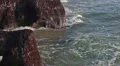 Camera review of breaking rocks waves then beach with liighthouse HD Footage