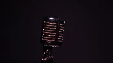 Camera revolves around vintage glare microphone on stage in dark club close up. Stock Footage 118544152
