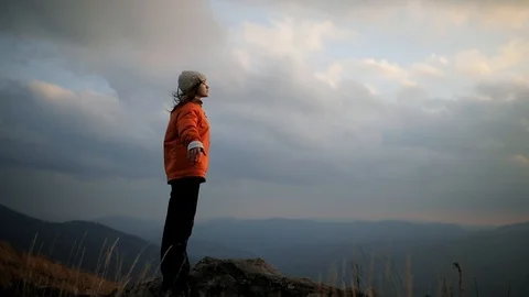 The camera revolves around a young beautiful woman standing on the edge of a Stock Footage 119585526