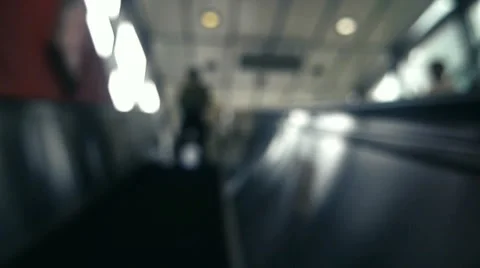 Camera riding up an escalator in to the light Stock Footage 50144880