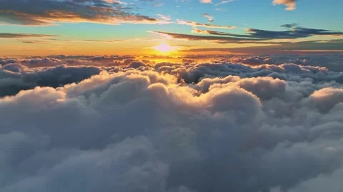 Camera rises above clouds, golden sunrise. Flying above the clouds illuminated Stock Footage 169694436