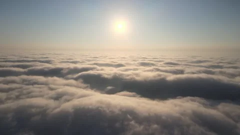 Camera rises above clouds, golden sunrise. Flying above the clouds illuminated Stock-Footage 249372434