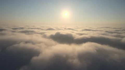 Camera rises above clouds, golden sunrise. Flying above the clouds illuminated Stock-Footage 249372815