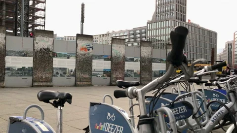 Camera rises from behind bike share scheme to show Berlin Wall Stock Footage 143242037