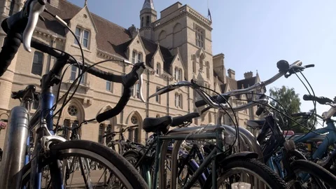 Camera rises from behind bikes to reveal Balliol College Stock Footage 97433959