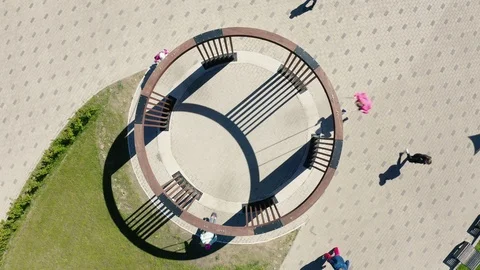 Camera rises over round swings in green park on sunny day Stock Footage 120881189