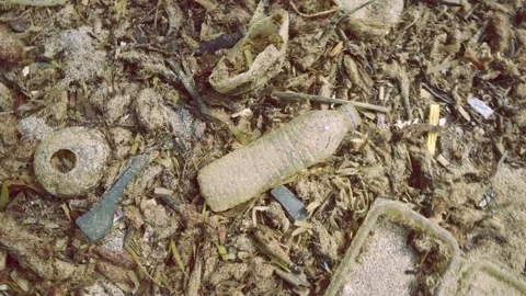 Camera rises up spiral above seabed covered with a lot of plastic garbage, Stock Footage 249755082