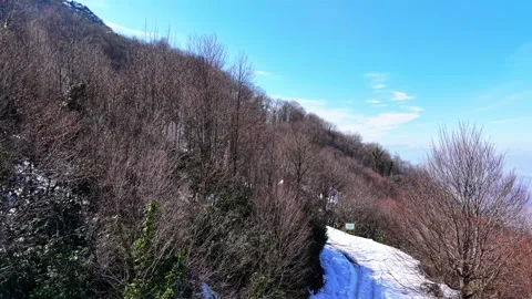 The camera rises upwards on the snowy road, capturing the scenery Vídeo Stock 334789154