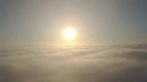 Camera rising over clouds and fog against the sun Stock Footage 144149536