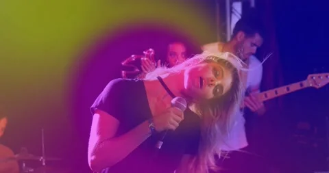 Camera rising revealing lead singer singing music for crowd, neon lights Stock Footage 334111775