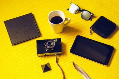 A camera on the road. notebook for writing, coffee cheer, wallet and tablet Stock Photos