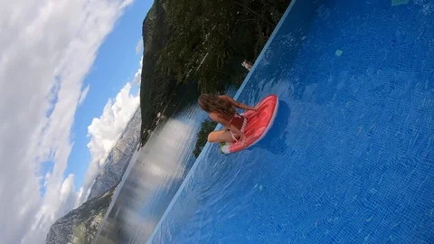 Camera rotates and falls into the pool overlooking a beautiful slim Video stock 117574928