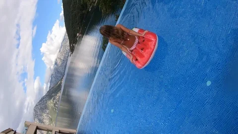 Camera rotates and falls into the pool overlooking a beautiful slim Video stock 117574951