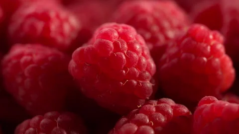 Camera rotates around a central raspberry, which is amid a pile of berries. Vídeo Stock 314179235